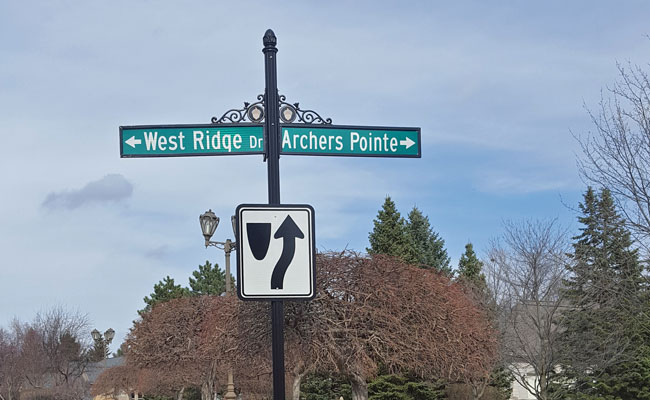 Subdivision street sign with directional sign beneath it