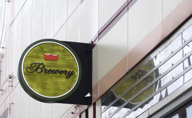 A carved wood blade sign for a brewery
